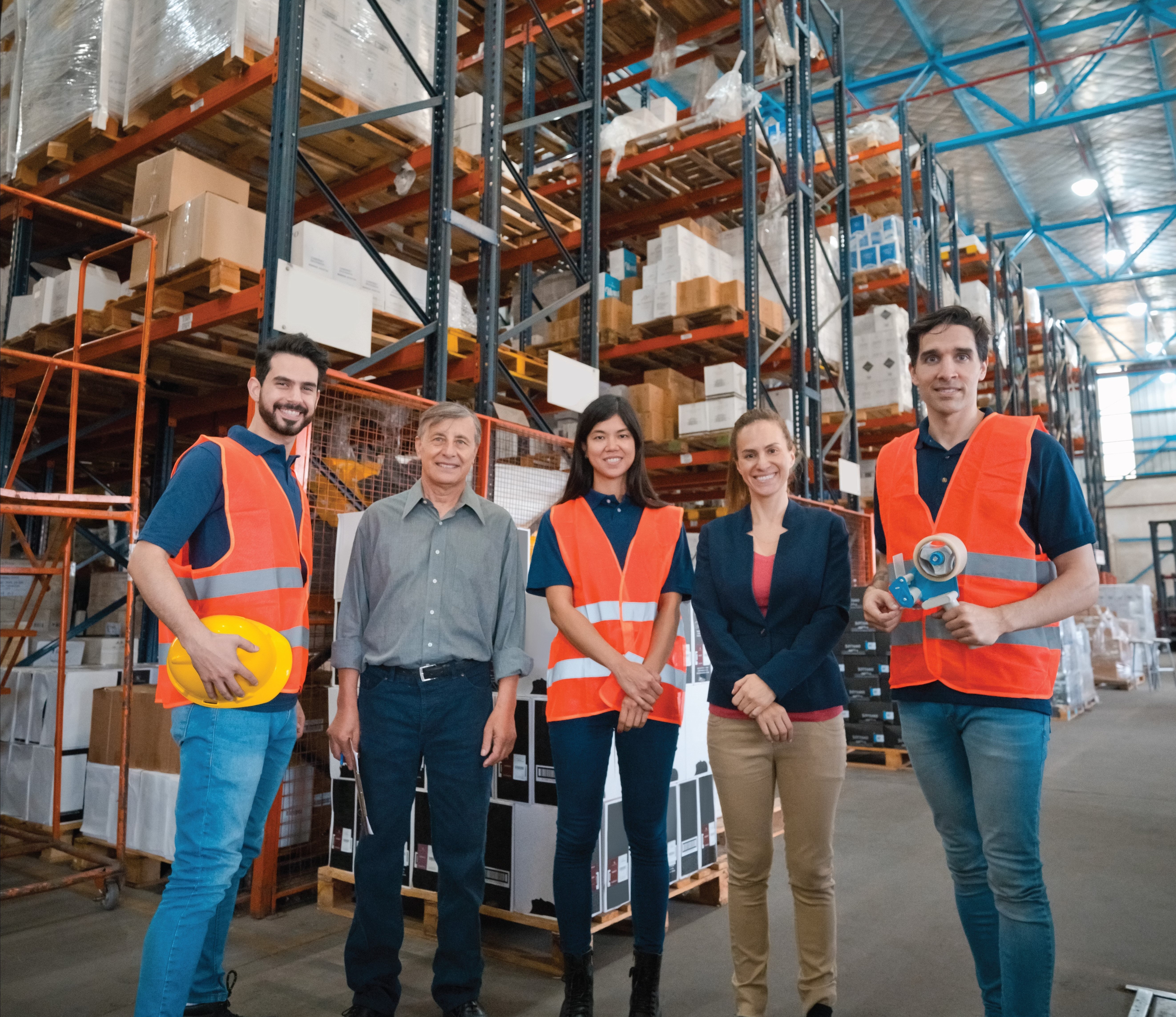Image: 6 individuals standing in warehouse.